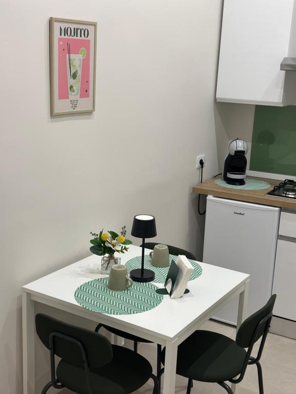 una mesa blanca con dos sillas y una mesa con flores. en NINAS HOME AiRPORT, en Catania