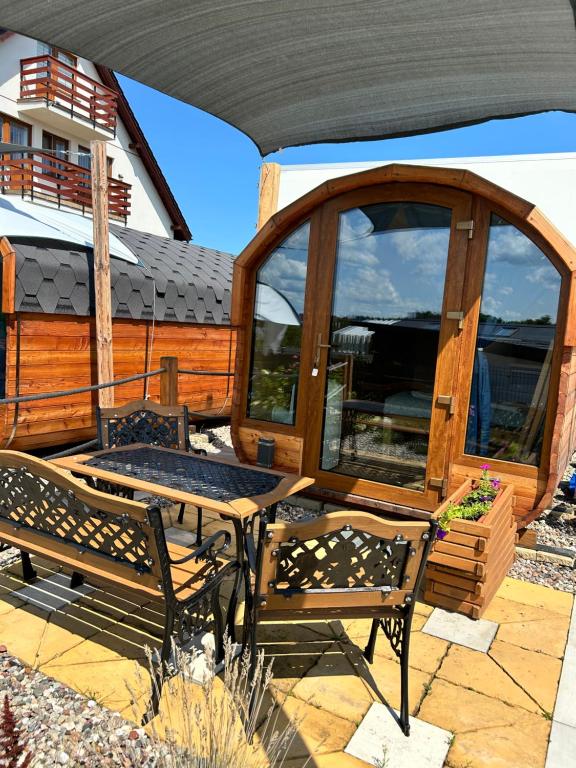 a patio with two benches and a gazebo at Zatoka Marina II in Mechelinki