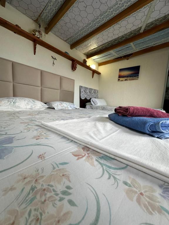 a large white bed in a room with a flower pattern at Villa Zeko in Gjirokastër