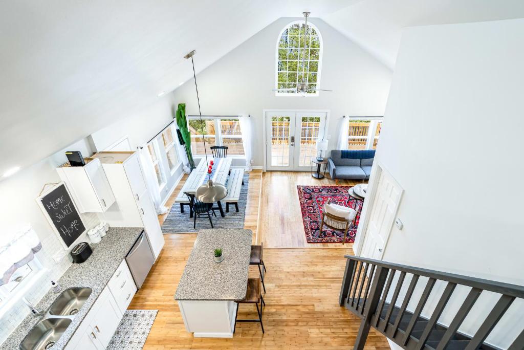 a kitchen and living room with a table and chairs at Loft Cabin w, Hot Tub, Fire Pit, Huge Deck & WiFi! in Hedgesville