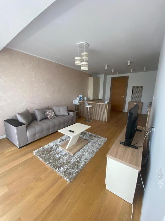 a living room with a couch and a tv at Apartament Naty S 403 Vogh Olimp in Olimp