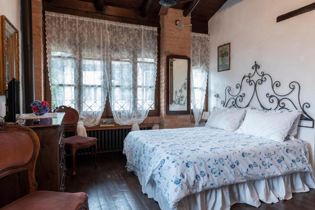 a bedroom with a bed in a room with windows at La Buca in Castello di Serravalle