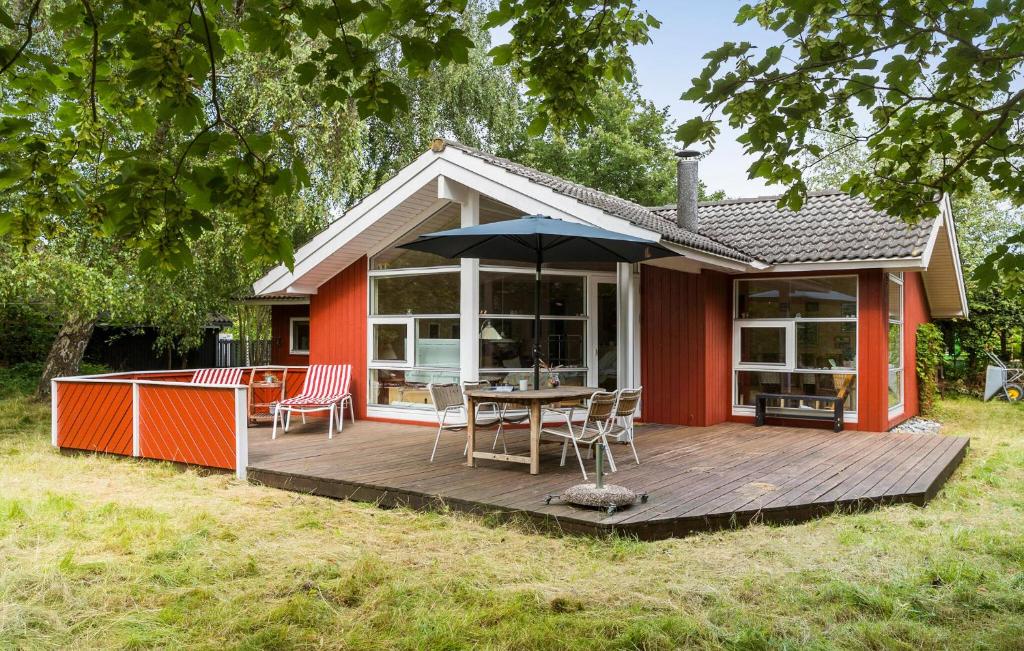 a house with a wooden deck with a table and an umbrella at 2 Bedroom Gorgeous Home In Slagelse in Slagelse