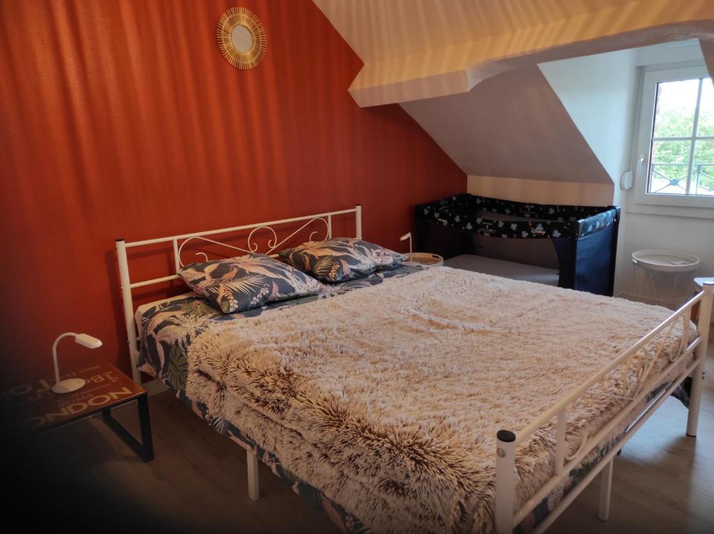 アランソンにあるla maison du bonheurのベッドルーム1室(オレンジ色の壁のベッド1台付)