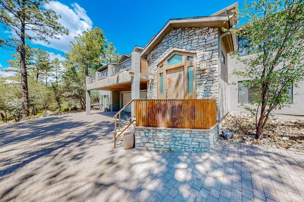 a stone house with a wooden door on a driveway at Elegant Cabin Among the Pines-Views, Near Downtown in Prescott