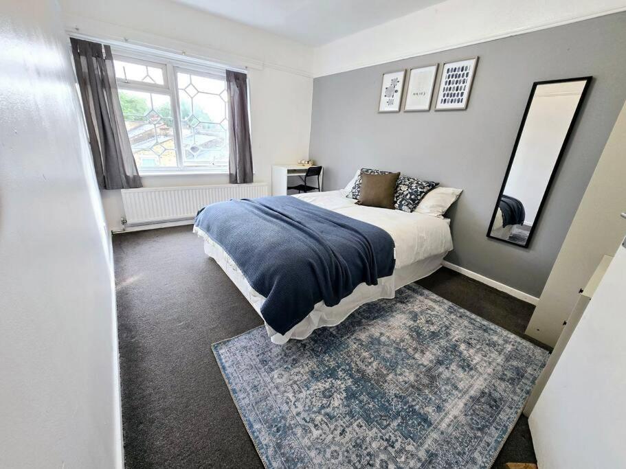 a bedroom with a bed and a mirror and a rug at Beautiful rooms in PRIME location! in London