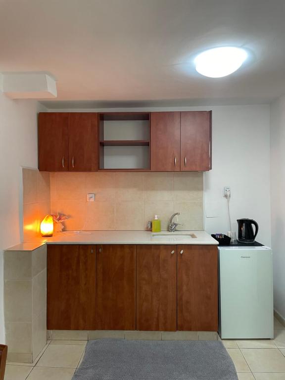 a kitchen with wooden cabinets and a white refrigerator at Eilat Beach House in Eilat