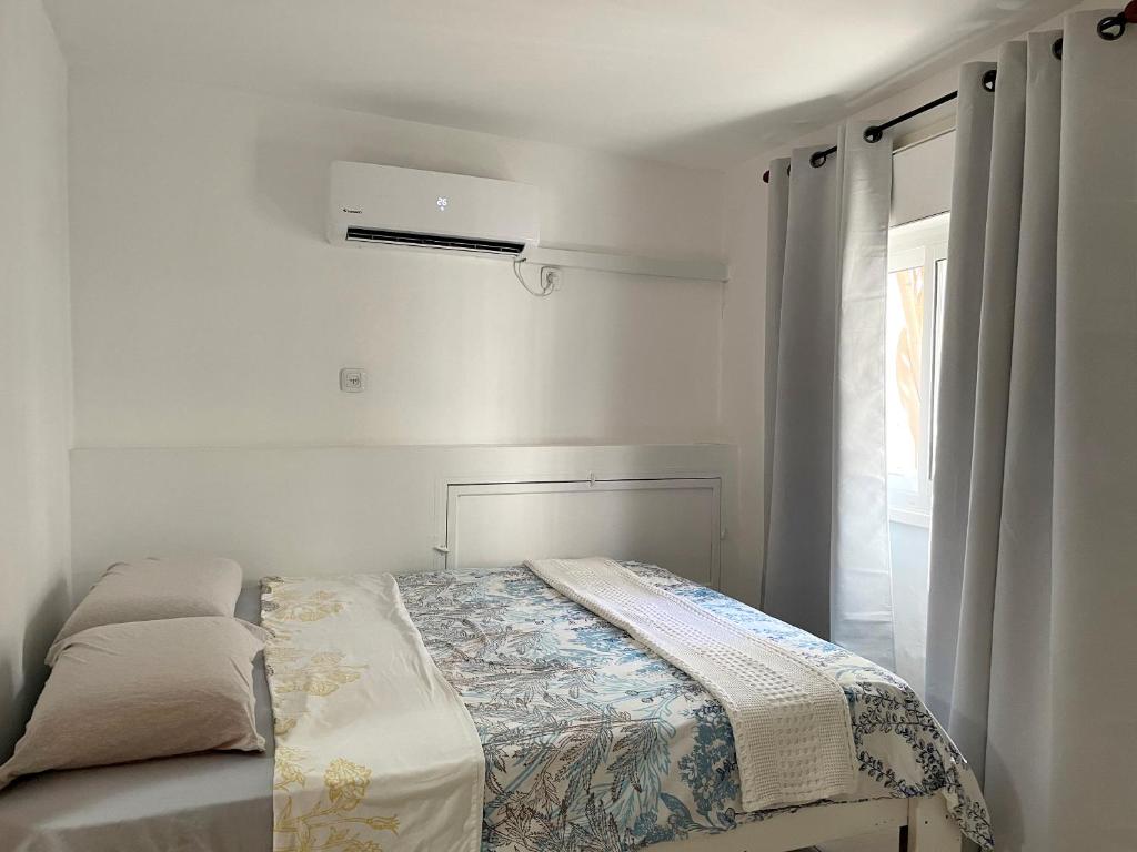 a small bedroom with a bed and a window at Eilat Beach House in Eilat