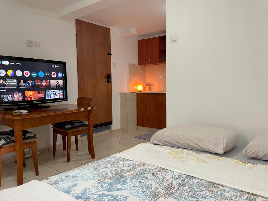 a bedroom with a bed and a desk with a flat screen tv at Eilat Beach House in Eilat