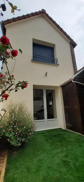 une maison avec une pelouse verte devant elle dans l'établissement L'Escapade Tréportaise, au Tréport