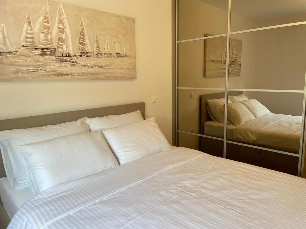 Un dormitorio con una cama blanca y un espejo. en Remi, en Slavonski Brod