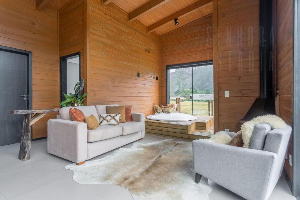 Una sala de estar con dos sofás y una chimenea. en Cabana do Lago - Villas Mornas Natureza e Jacuzzi, en Aguas Mornas