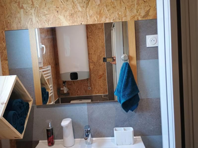 a bathroom with a sink and a mirror with a blue towel at Gîte Bleu Confort et Nature in Sennecey-le-Grand