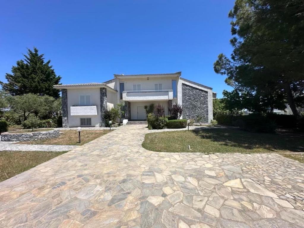 a house with a stone driveway in front of it at Paliouri Cottage by Luxlikehome in Paliouri