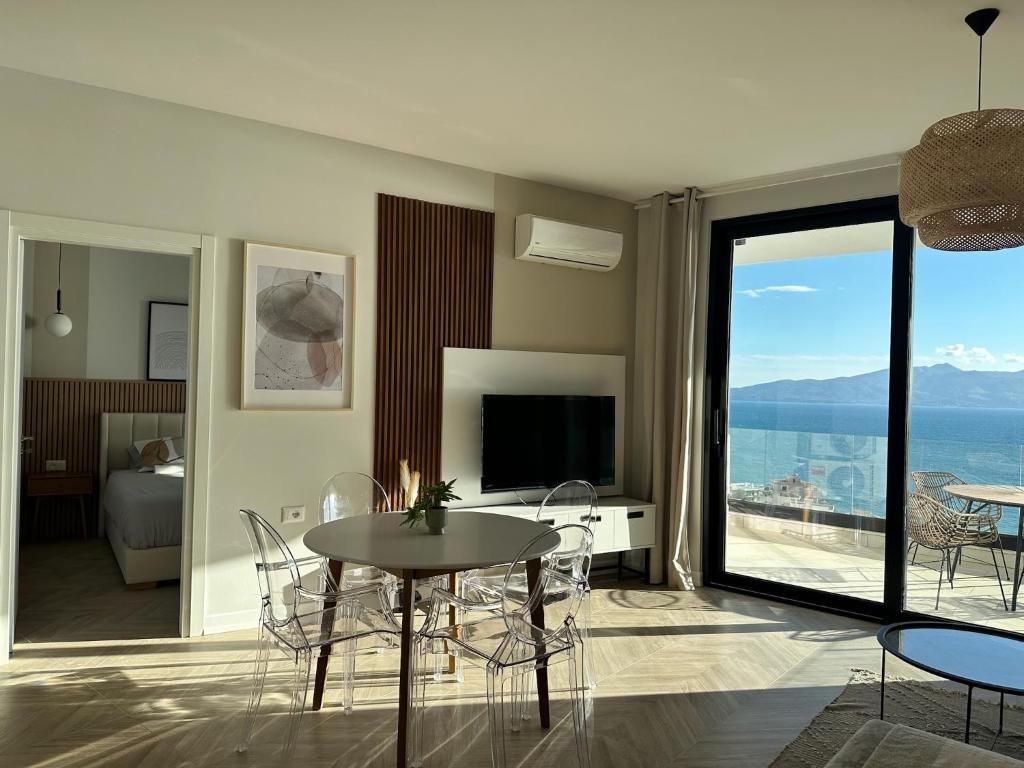 a living room with a table and a view of the ocean at Veronica Apartment in Sarandë