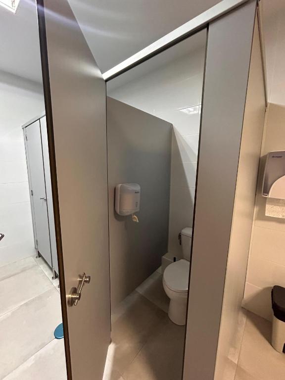 a bathroom with a toilet and a glass door at Hostel Sorolla Playa in Málaga