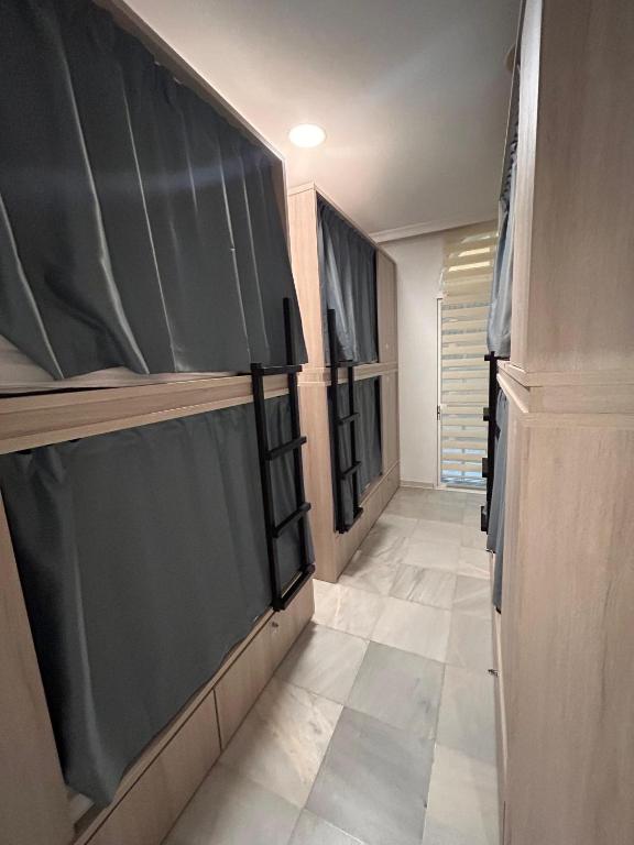 a hallway with black cabinets and a tiled floor at Hostel Sorolla Playa in Málaga