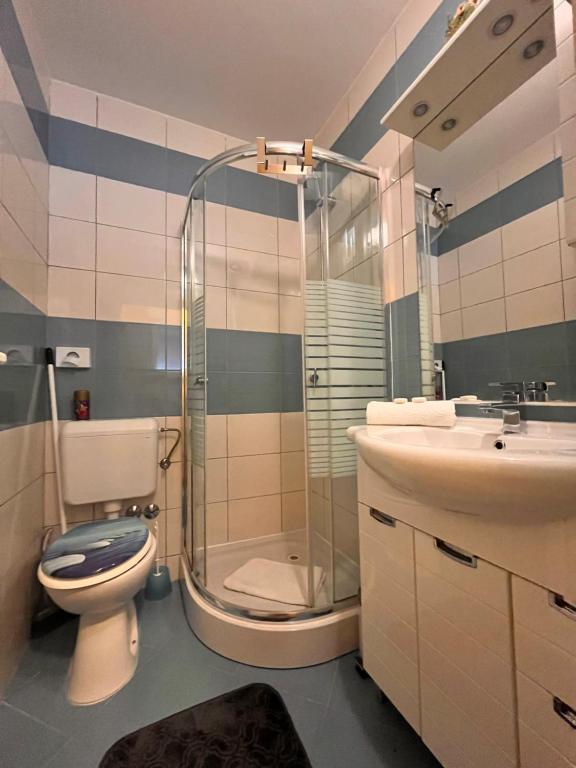 ein Badezimmer mit Dusche, Toilette und Waschbecken in der Unterkunft Apartments Kristal in Kaštela