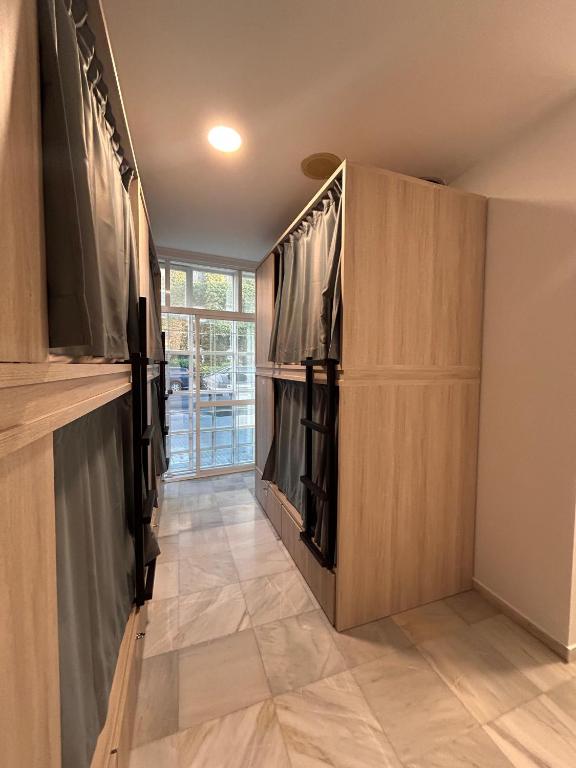 a walk in closet with wooden cabinets and a tile floor at Hostel Sorolla Playa in Málaga