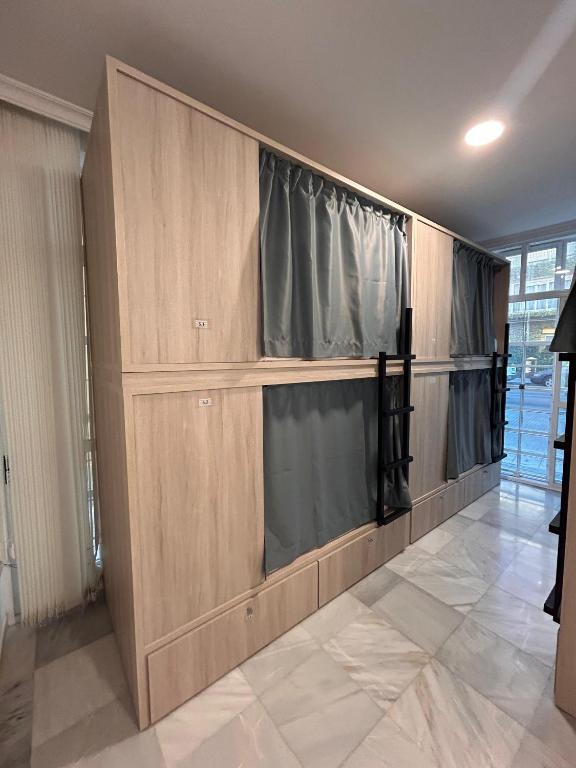 a room with wooden cabinets and a window at Hostel Sorolla Playa in Málaga
