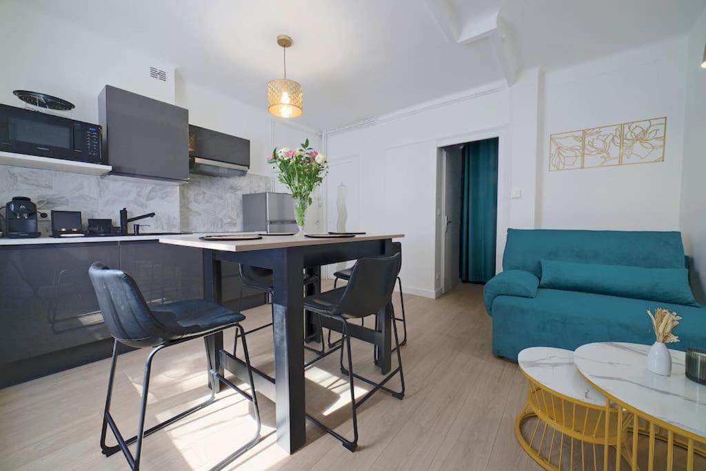 un salon avec une table et un canapé bleu dans l'établissement Appartement COSY Gare Chateaucreux, à Saint-Étienne