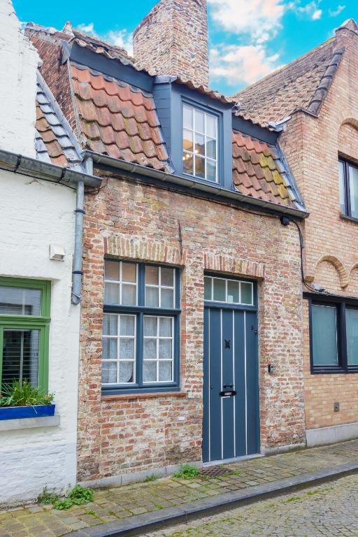 a brick house with a blue door and windows at La maisonnette du Prince in Bruges