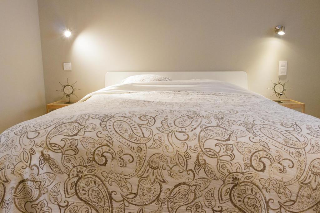Un dormitorio con una cama grande con un edredón blanco. en La maisonnette du Prince, en Brujas
