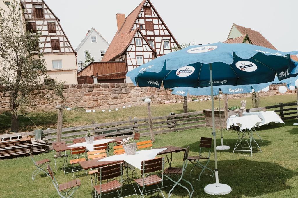 a group of tables and an umbrella in the grass at Bayerischer Hof Spalt in Spalt