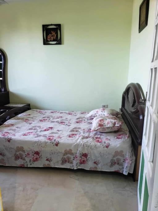 a bedroom with a bed with a floral bedspread at studio confortable in Tabarka