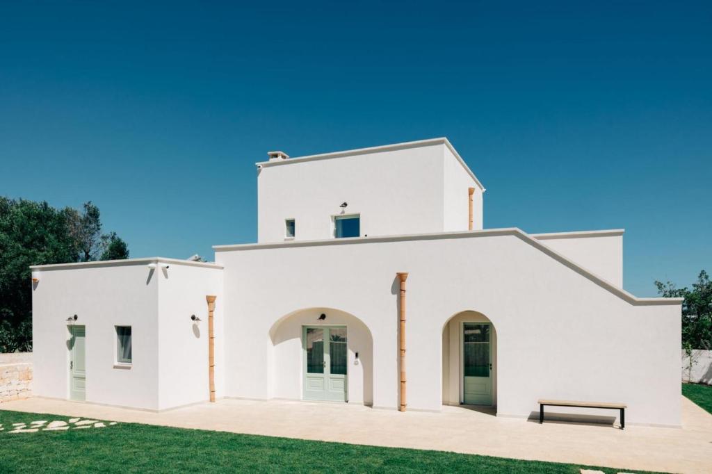 a white house with a bench in front of it at Dimora Stune in Ostuni