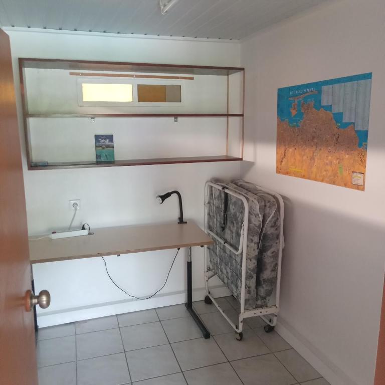 La salle de bains est pourvue d'un bureau, d'un lavabo et d'un miroir. dans l'établissement Fare MIHIMANA, à Paea