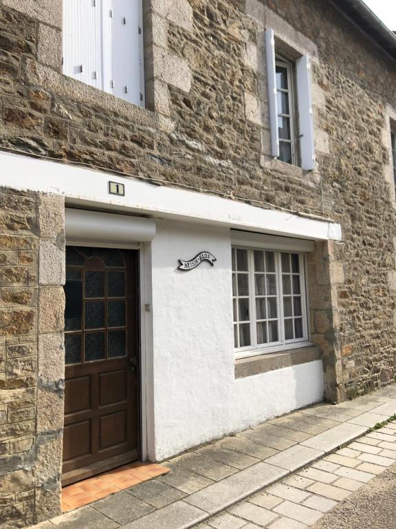 un bâtiment avec un garage avec un panneau représentant un cheval dessus dans l'établissement Neisik Kloz, à Saint-Briac-sur-Mer
