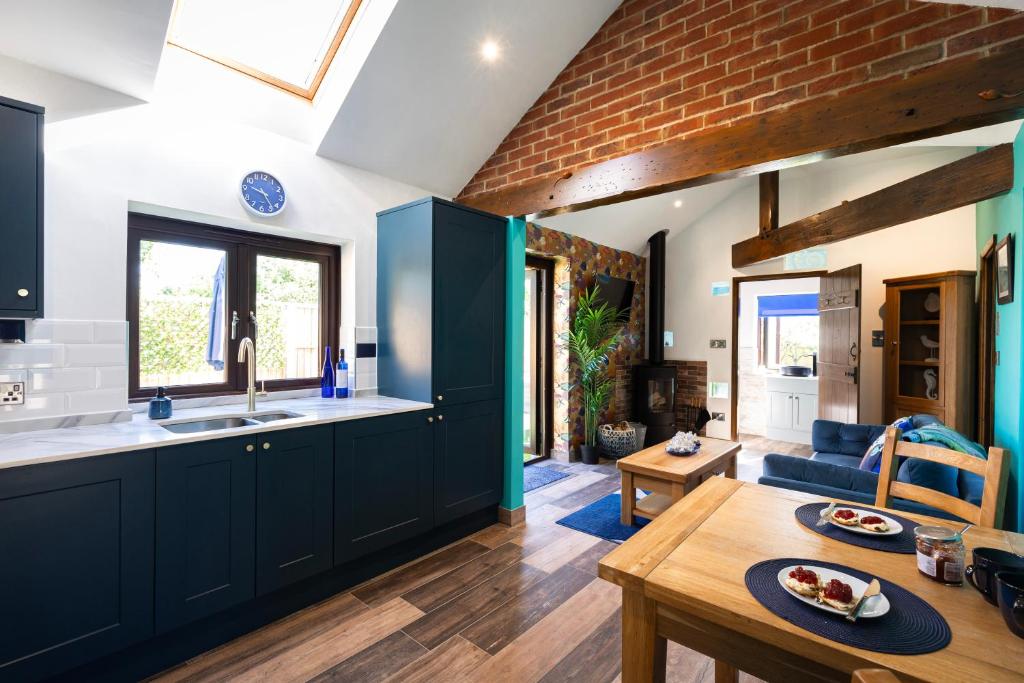 a kitchen with dark blue cabinets and a table at Farm Elegance at Lottie's Lodge in Hutton