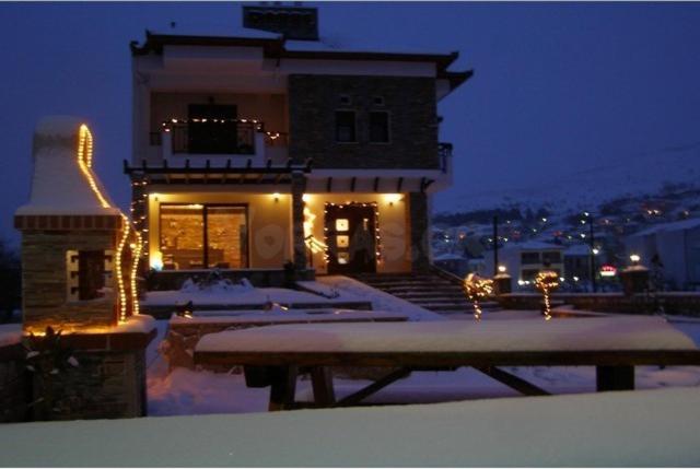 a building with a picnic table in the snow at night at Guesthouse 4 Seasons in Árnissa