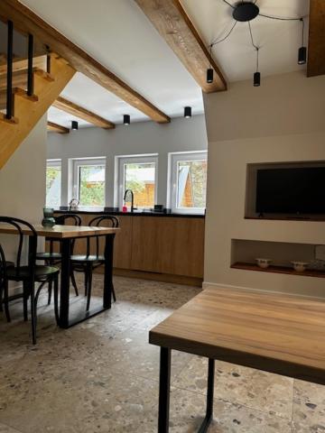 a living room with a table and chairs and a tv at Domki Sosnówka in Majdan Sopocki