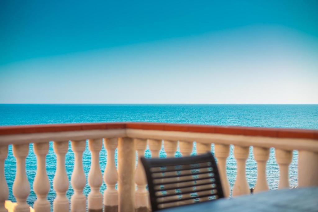 a chair sitting on a balcony overlooking the ocean at ALBACHIARA by CefaLux in Cefalù