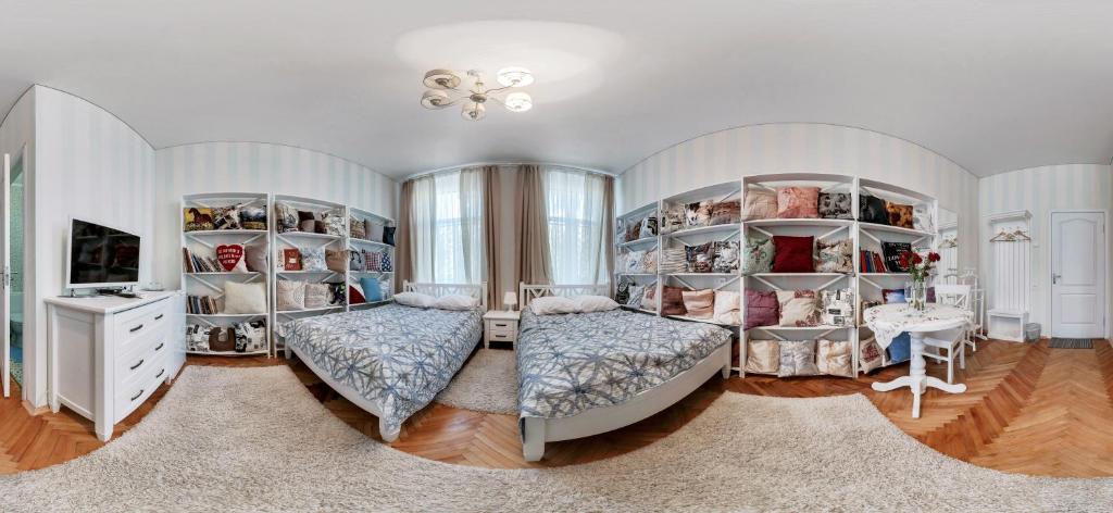 a bedroom with two beds and a room with shelves at Polska Poduszka in Lviv