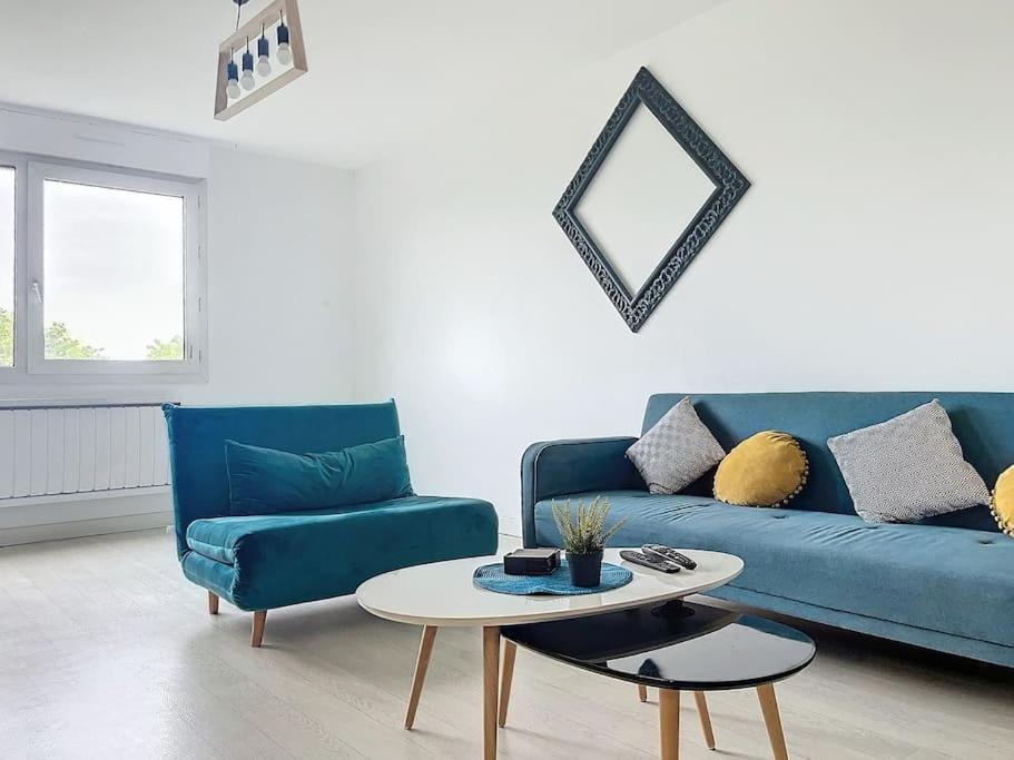 un salon avec un canapé bleu et une table dans l'établissement Grand appartement neuf entre Paris et Disneyland, à Noisy-le-Grand