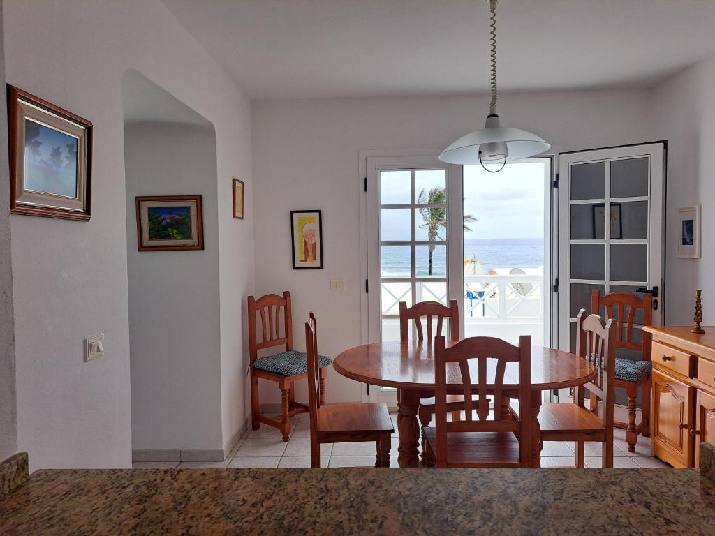 un comedor con mesa y sillas y el océano en Casa La Marea, en Arrieta