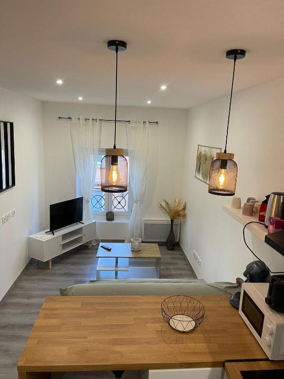 - un salon avec deux lampes suspendues et une table dans l'établissement Charmant Appart clim 6 pers, Sorgues Vaucluse 2, à Sorgues