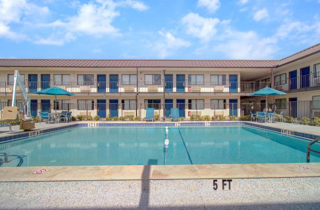 a swimming pool in front of a building at Motel 6-Venice, FL in Venice