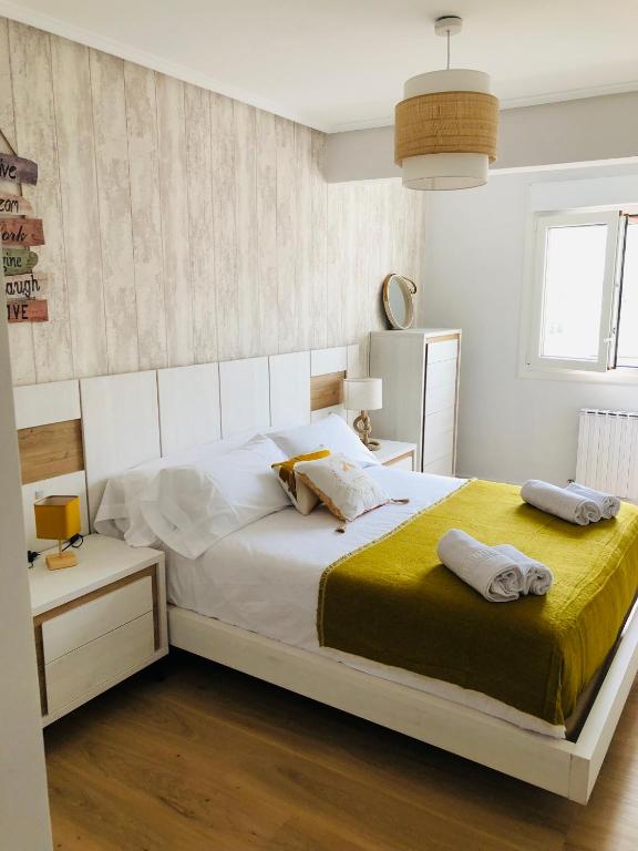 a bedroom with a bed with two towels on it at Alojamiento Mar y Bienestar in Laredo
