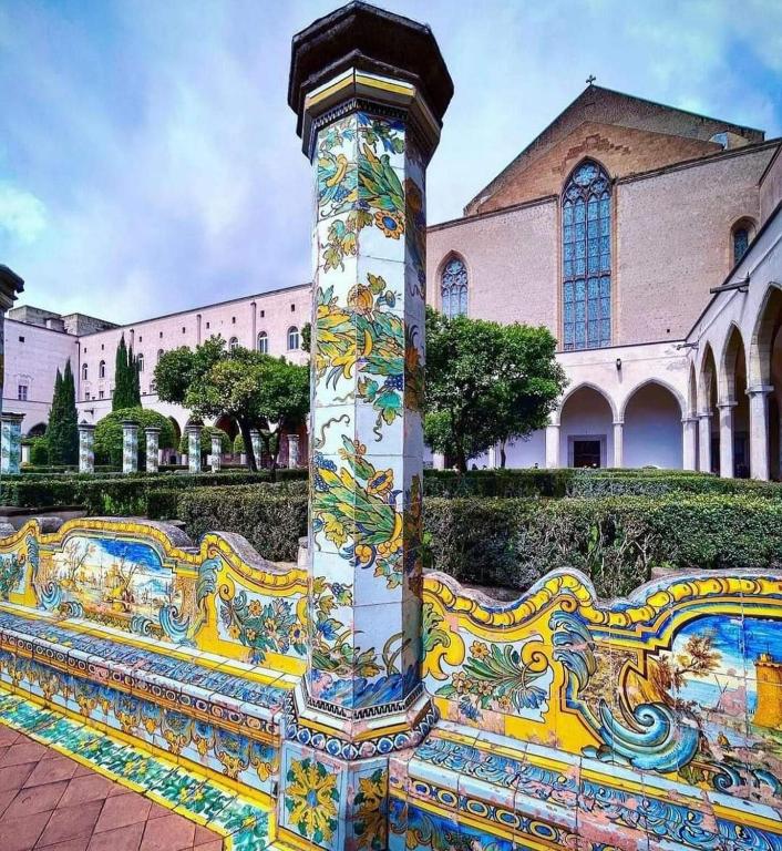 una panchina colorata di fronte a un edificio di Risvegli Partenopei House a Napoli