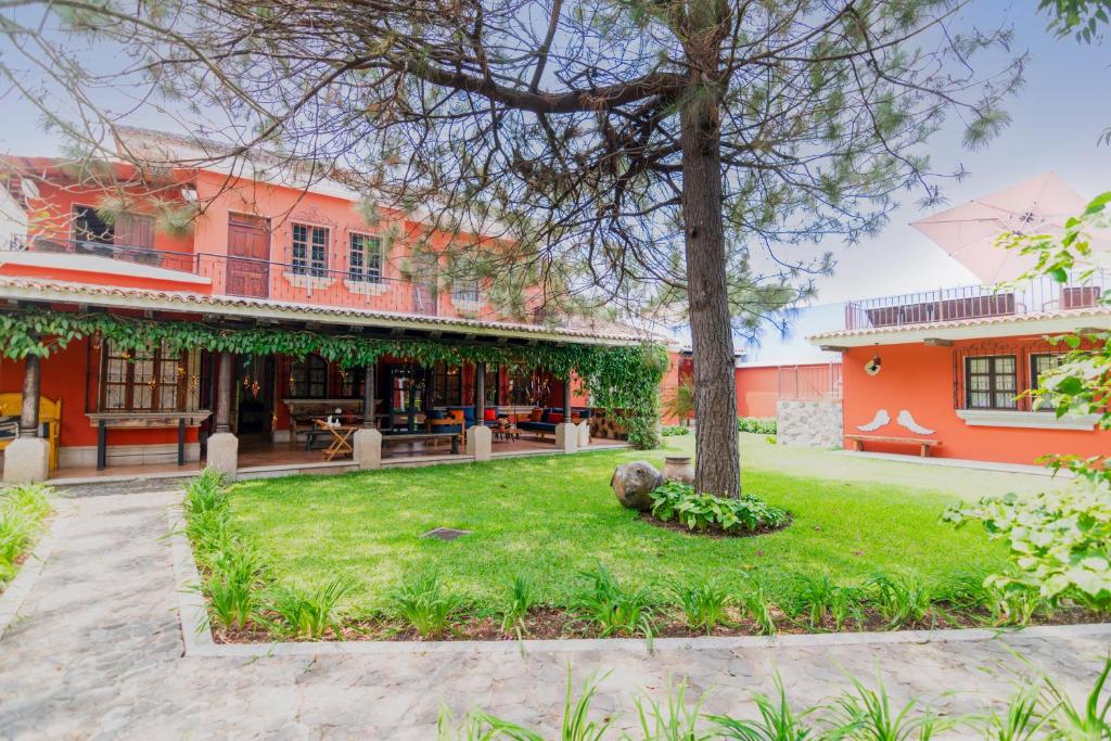 a courtyard with a tree and a building at Santa Margarita in Antigua Guatemala