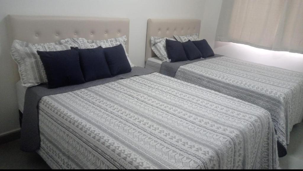 2 Betten mit blauen Kissen in einem Zimmer in der Unterkunft Casa Costa do conde in Conde