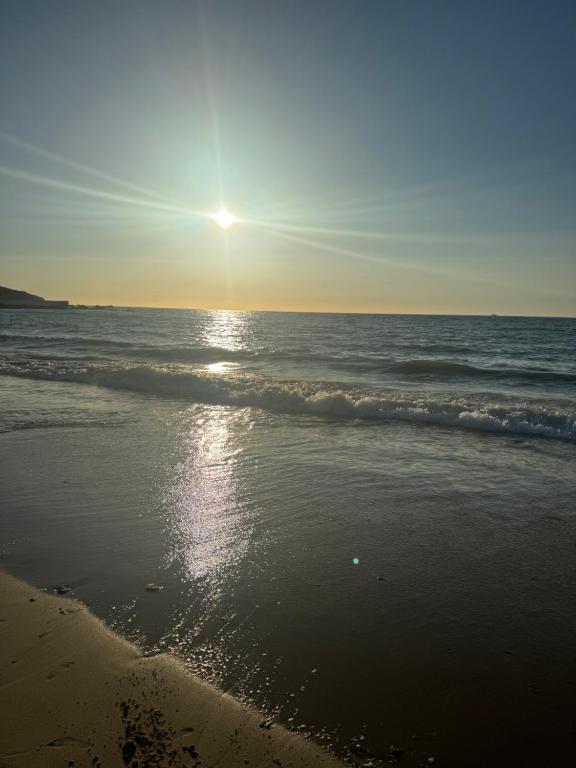 a beach with the sun rising over the ocean at Luxury apartment near TGV station and the beach in Tangier