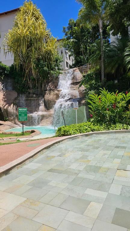 a swimming pool with a waterfall in a park at Hotel Luupi Esmeralda Apto 159 - Rio Quente GO in Rio Quente