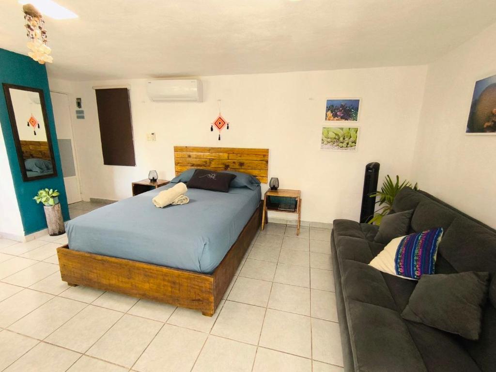 a bedroom with a bed and a couch at Comfy studio Yaxkin on downtown, 3 block away from sea and sunsets in Cozumel
