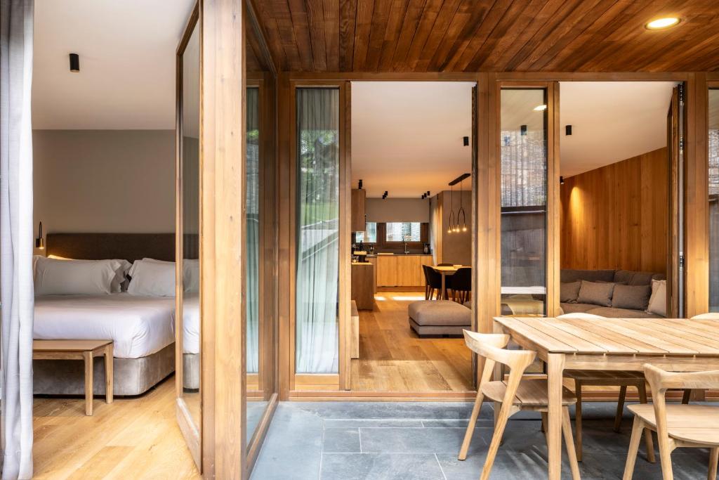 a bedroom with a bed and a table in a room at Un diamante de montaña l A Pie De Pistas - Gimnasio - Sauna - Piscina l 8Pax l by BonesVacances in El Tarter
