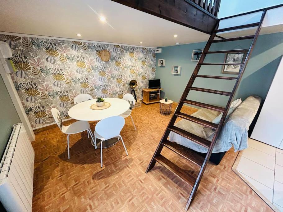 une chambre avec une table et des chaises et un escalier en colimaçon dans l'établissement Jolie petite maison en duplex, à Gravelines